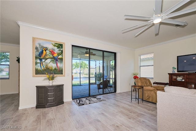 living room featuring ornamental molding, ceiling fan, and light wood-type flooring