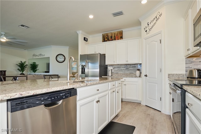 kitchen with white cabinetry, light stone counters, stainless steel appliances, and crown molding