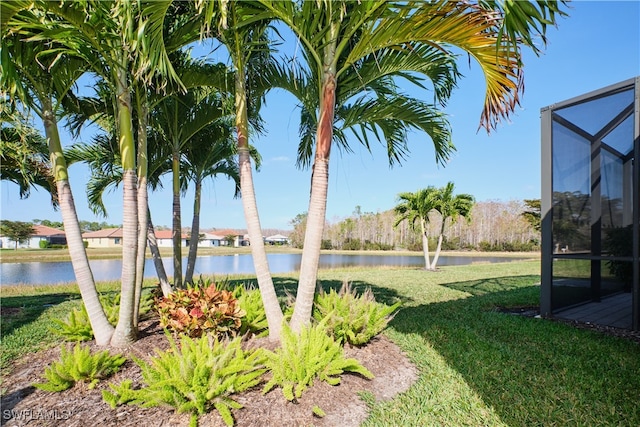 view of yard featuring a water view and glass enclosure