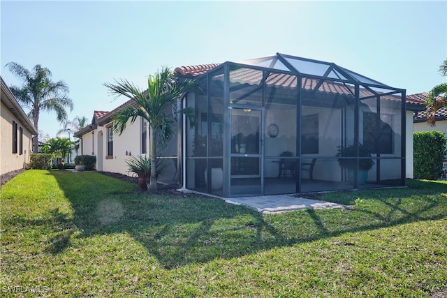 back of property featuring a lanai, a lawn, and a patio area