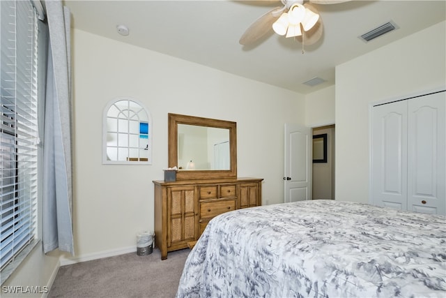 carpeted bedroom with ceiling fan and a closet