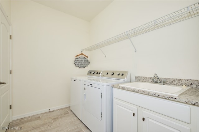 laundry room featuring sink, cabinets, and washer and dryer