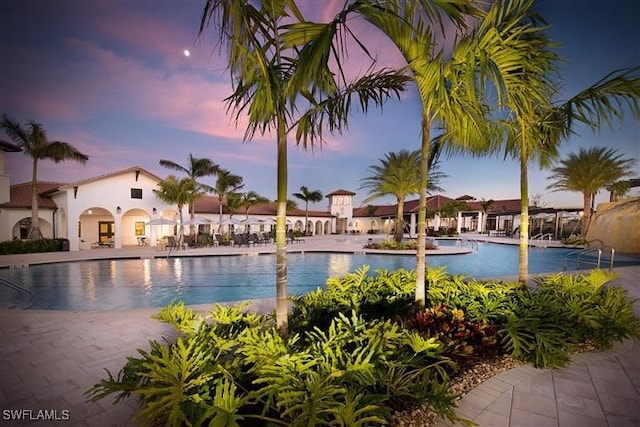 pool at dusk featuring a patio area