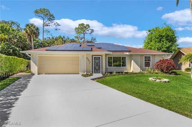 single story home featuring a garage, driveway, roof mounted solar panels, a front lawn, and stucco siding