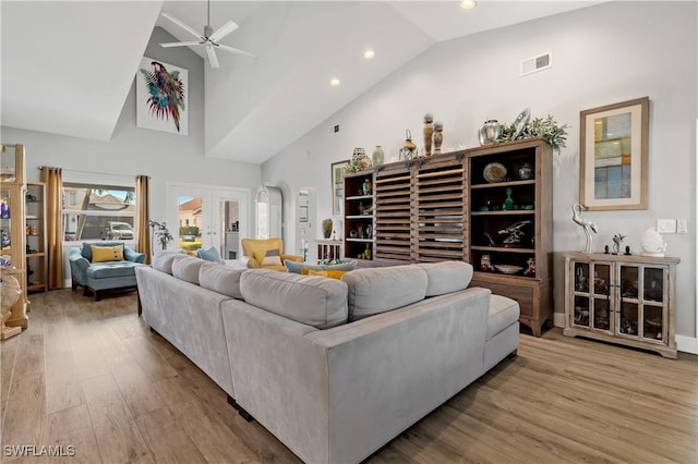 living room featuring french doors, ceiling fan, high vaulted ceiling, and light wood-type flooring