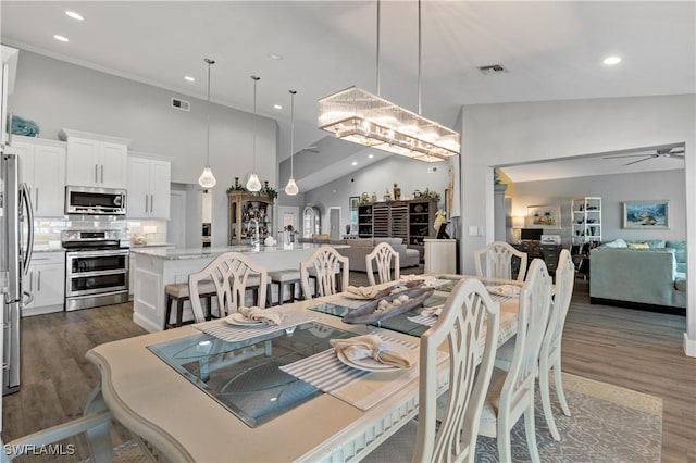 dining area featuring dark hardwood / wood-style floors, ceiling fan, and a high ceiling