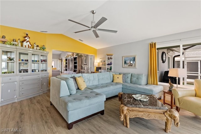 living room featuring ceiling fan, lofted ceiling, and light hardwood / wood-style floors