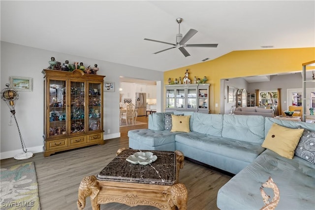 living room with hardwood / wood-style floors, vaulted ceiling, and ceiling fan