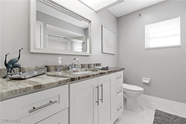 bathroom with vanity, a shower with shower door, and toilet