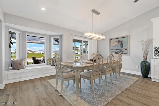 dining area featuring lofted ceiling and light wood-type flooring