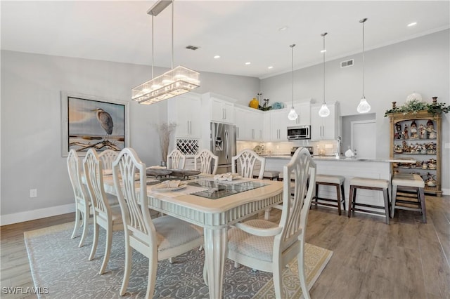 dining space featuring hardwood / wood-style floors and a high ceiling