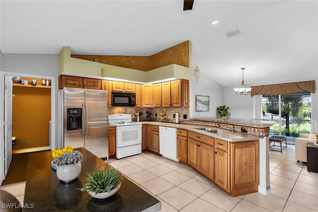 kitchen with an inviting chandelier, vaulted ceiling, kitchen peninsula, pendant lighting, and white appliances