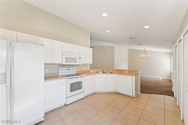 kitchen with hanging light fixtures, white appliances, kitchen peninsula, and white cabinets