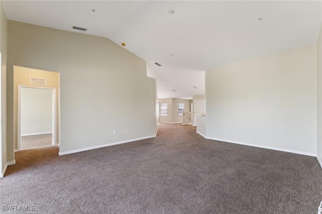 spare room featuring lofted ceiling and dark carpet