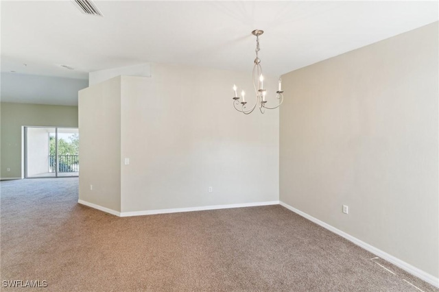 empty room featuring carpet floors and an inviting chandelier