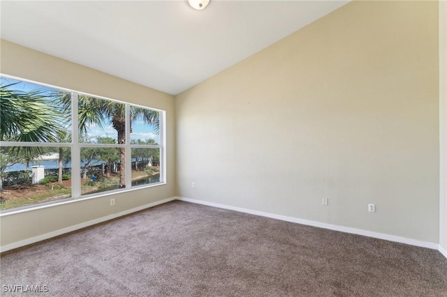 carpeted spare room featuring lofted ceiling