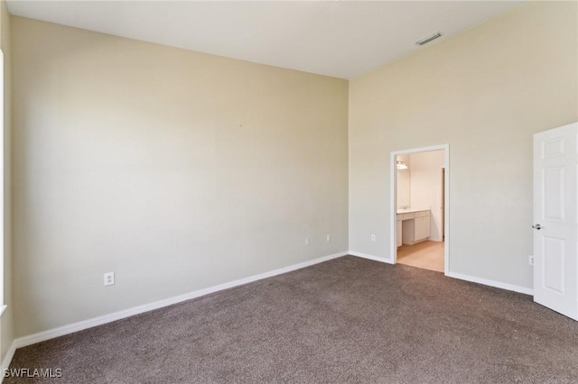 unfurnished bedroom with connected bathroom and light colored carpet