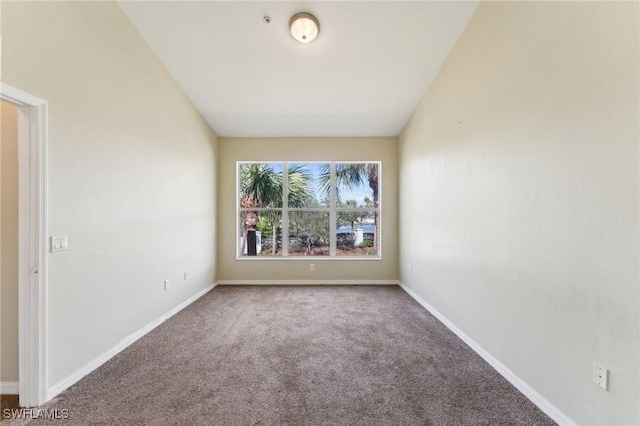 spare room with vaulted ceiling and carpet flooring