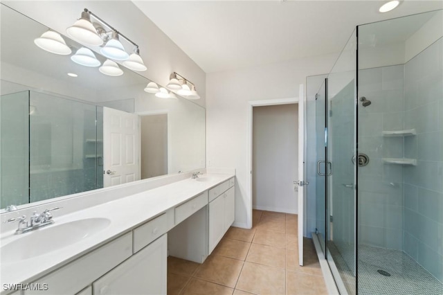 bathroom with an enclosed shower, vanity, and tile patterned floors