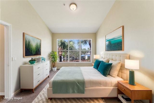 bedroom featuring lofted ceiling and carpet flooring