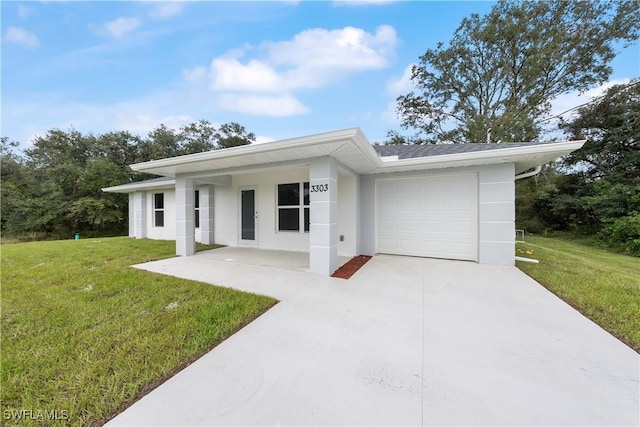 view of front facade with a garage, a front yard, concrete driveway, and stucco siding