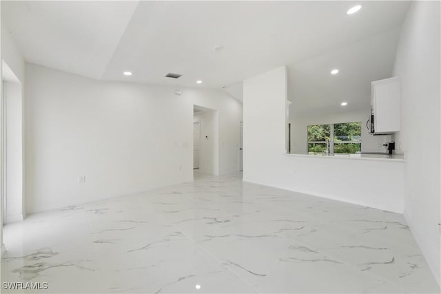 empty room with lofted ceiling, marble finish floor, visible vents, and recessed lighting