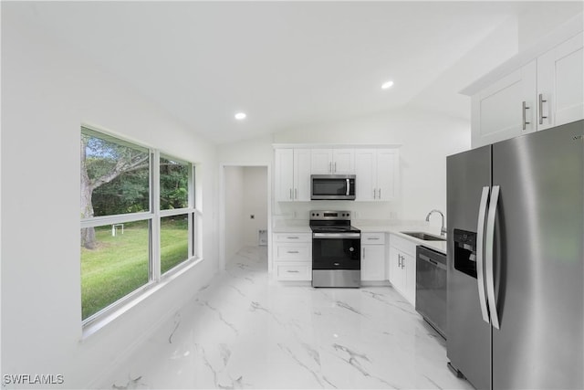 kitchen with marble finish floor, stainless steel appliances, light countertops, white cabinets, and a sink