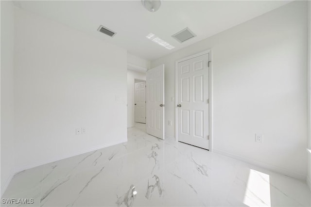 empty room featuring marble finish floor, visible vents, and baseboards