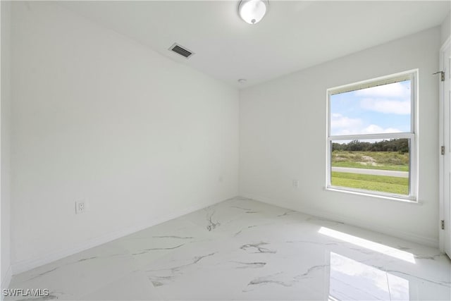 unfurnished room featuring marble finish floor, visible vents, and baseboards