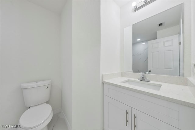 bathroom with toilet, baseboards, visible vents, and vanity