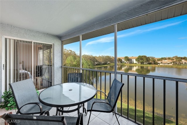 sunroom featuring a water view