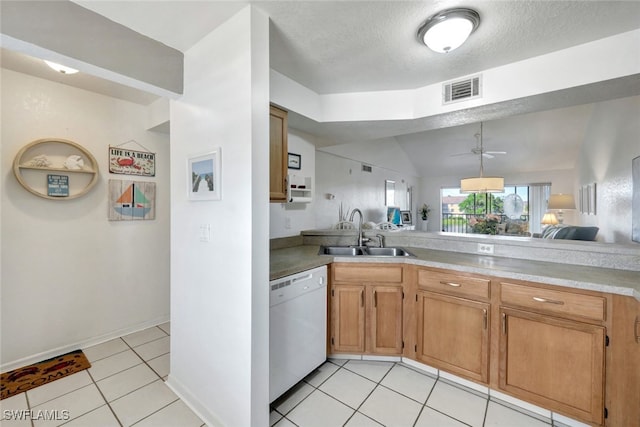 kitchen featuring lofted ceiling, sink, light tile patterned floors, dishwasher, and a textured ceiling