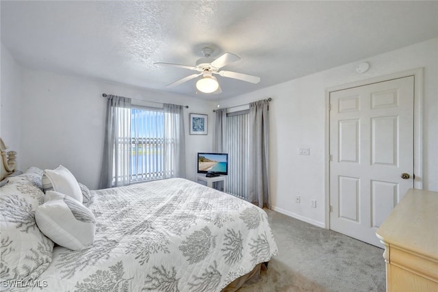 carpeted bedroom featuring a textured ceiling and ceiling fan