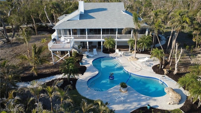 view of swimming pool with a patio and a sunroom