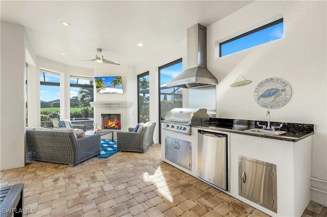 view of patio / terrace featuring an outdoor living space with a fireplace, a grill, sink, area for grilling, and ceiling fan