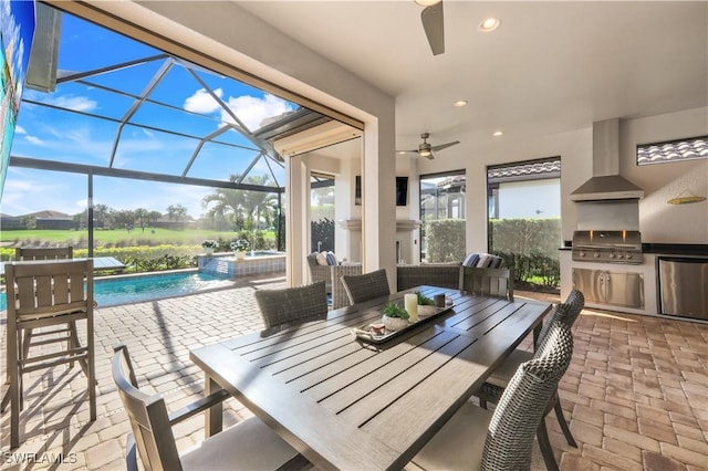 view of patio / terrace with a grill, a lanai, ceiling fan, and an outdoor kitchen