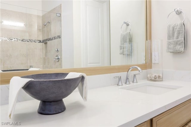 bathroom with vanity and tiled shower