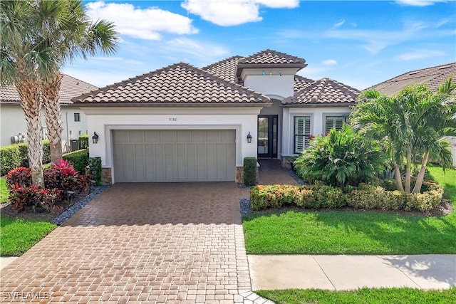 mediterranean / spanish house with a garage and a front yard