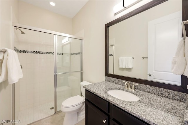 bathroom featuring vanity, toilet, tile patterned flooring, and a shower with door