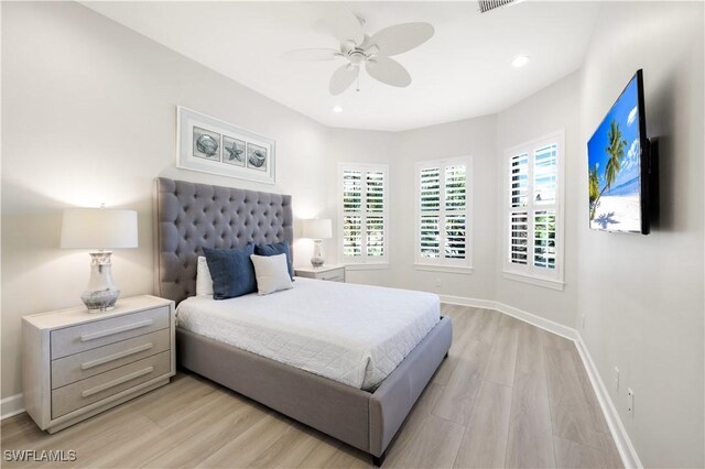 bedroom featuring multiple windows, light hardwood / wood-style flooring, and ceiling fan