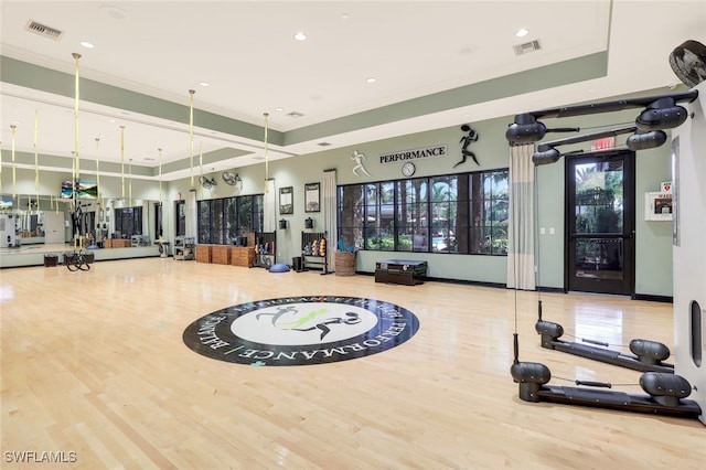 workout area with wood-type flooring and ornamental molding