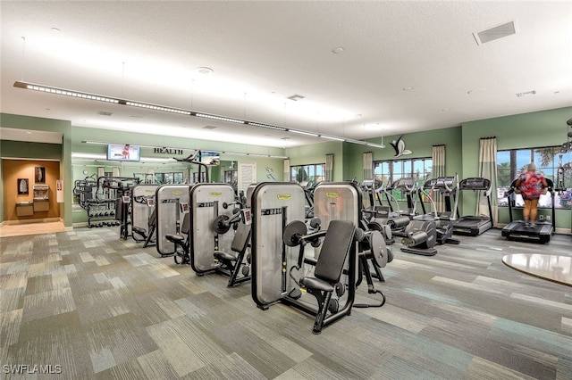 gym with light colored carpet and a textured ceiling