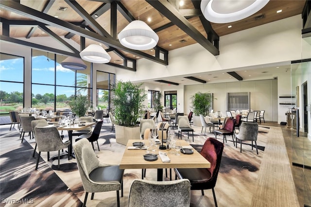 dining area featuring beamed ceiling, high vaulted ceiling, and hardwood / wood-style flooring