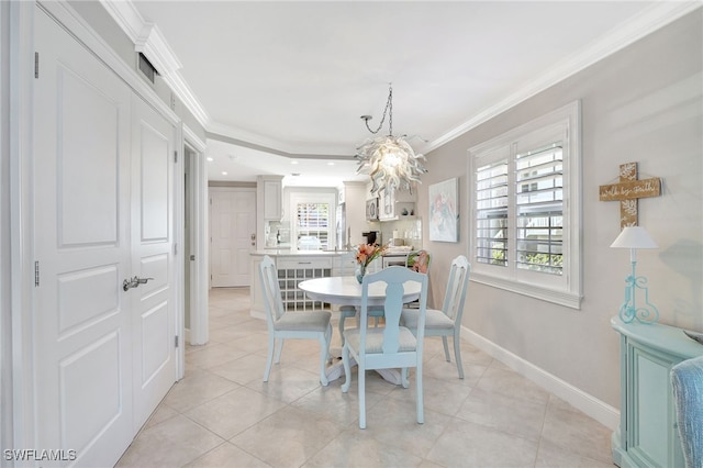 dining area featuring crown molding, a chandelier, and light tile patterned floors