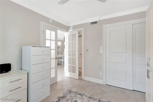 interior space featuring french doors, crown molding, and light tile patterned floors