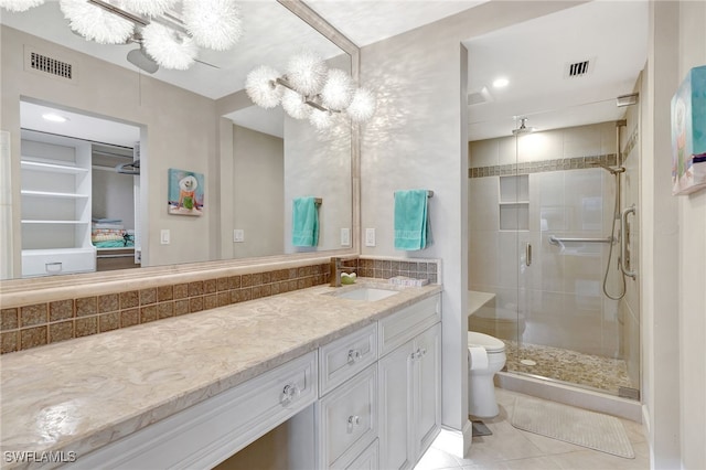 bathroom with vanity, tile patterned flooring, toilet, and walk in shower