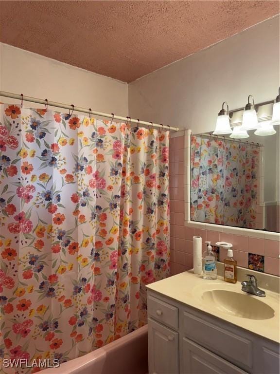 bathroom with shower / bath combination with curtain, tasteful backsplash, vanity, and a textured ceiling