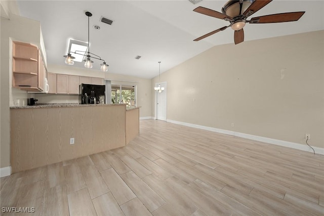 kitchen with vaulted ceiling, black refrigerator, decorative light fixtures, light brown cabinets, and light wood-type flooring