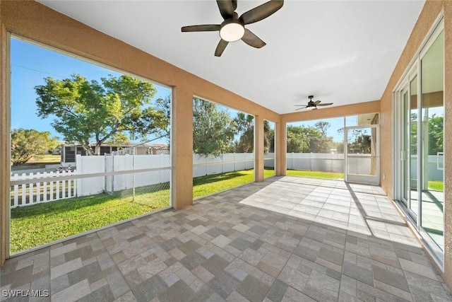 unfurnished sunroom featuring ceiling fan