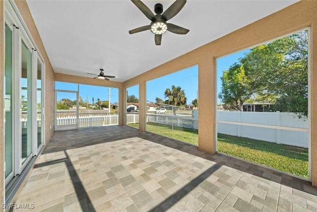 unfurnished sunroom featuring ceiling fan